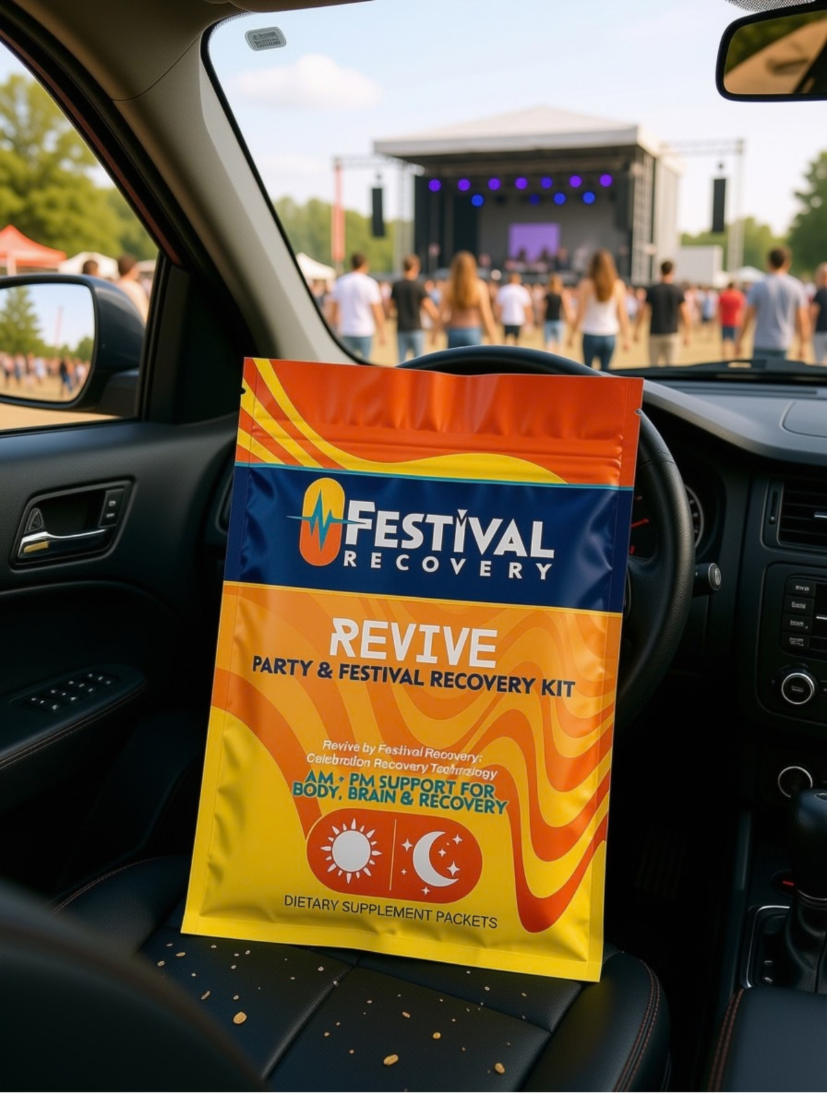 Festival Recovery REVIVE kit pouch on a car dashboard with a festival stage in the distance